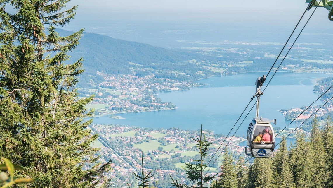 Abschnitt der Walbberg-Bahn mit Gondel und Tegernsee im Hintergrund